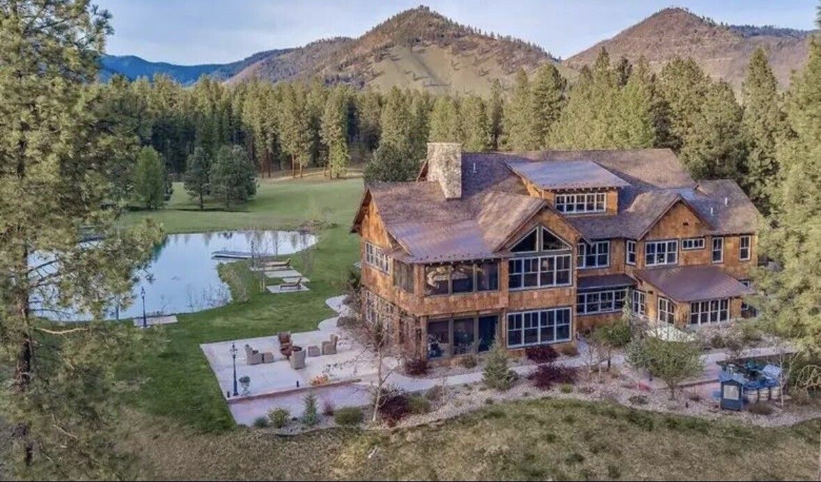 A timber lodge among pines in Montana ranch country, seen from above